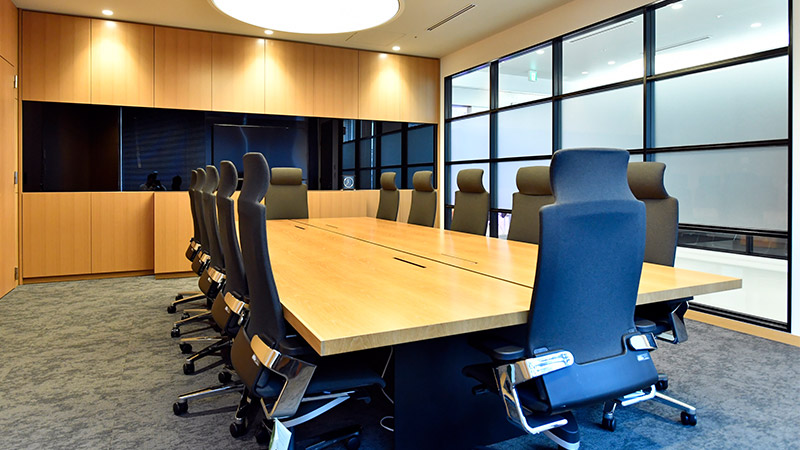 木目調のテーブルを囲む会議室